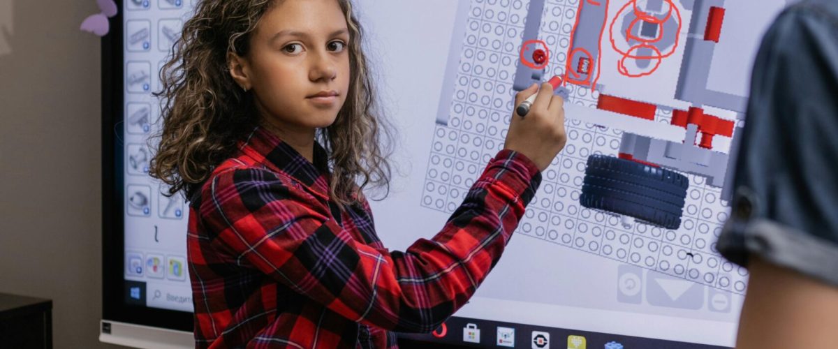 Girl using interactive board in a classroom exploring educational content.